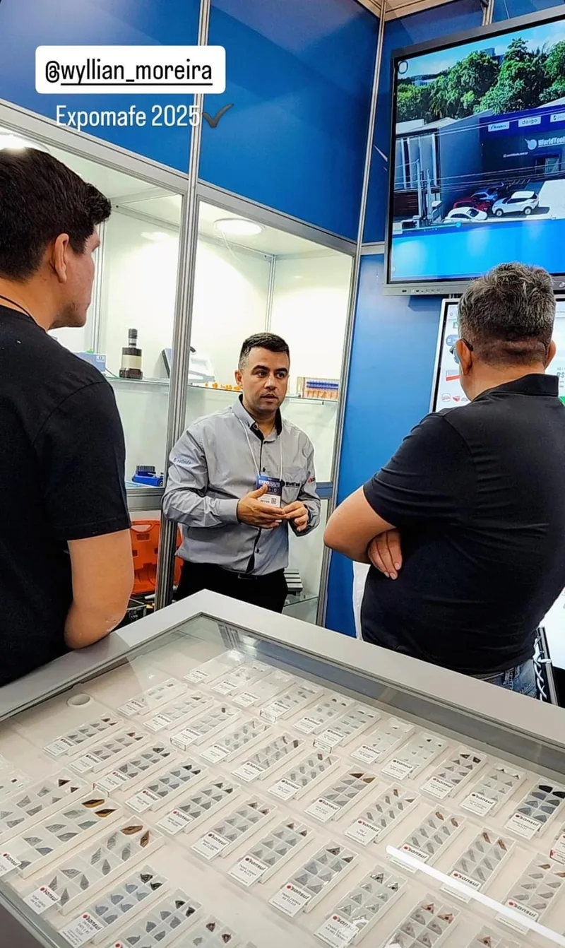 Atendimento na vitrine de insertos do estande da World Tools na Expomafe 2025, com TV apresentando o e-commerce