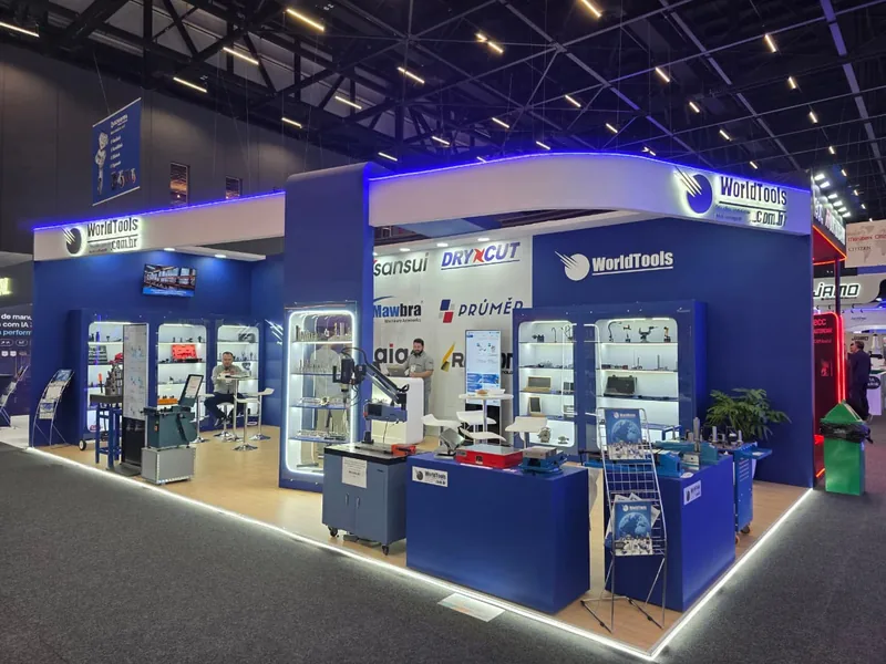 Vista geral do estande G019 da World Tools na Feimec 2026, com marquise de LED, torre central de vitrines iluminadas e bancadas de demonstração