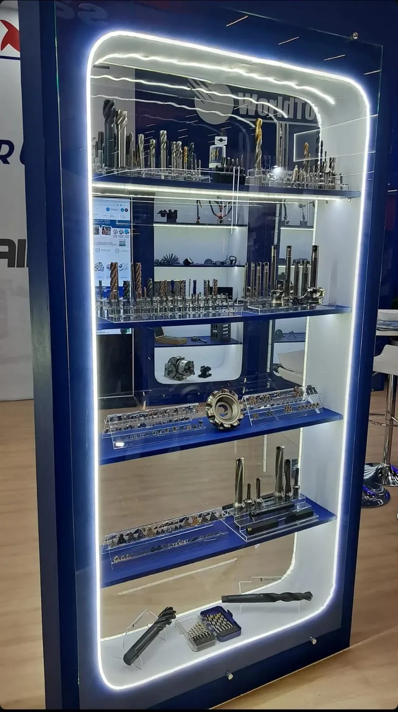 Vitrine vertical com iluminação de LED exibindo brocas, fresas e ferramentas de corte no estande da World Tools na Feimec 2026
